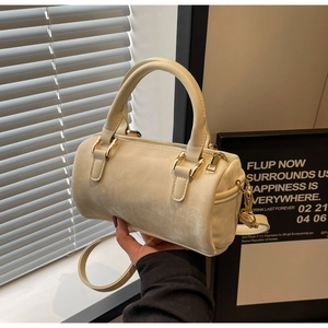 Detail of cream white boston bag showing soft suede texture and gold zipper hardware