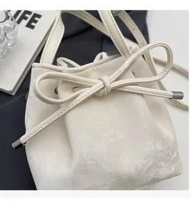 Détail du sac seau blanc avec cordon en cuir et embouts métalliques argentés