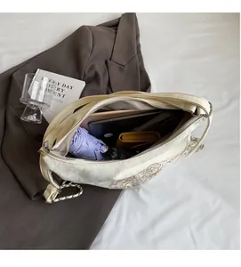 Detail of the spacious interior compartment of this embroidered bag holding daily essentials
