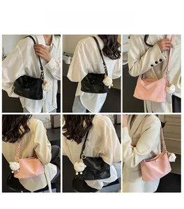 Detailed views of dumpling shoulder bags in black and pink with sheep charms
