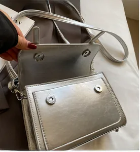Détails du sac bandoulière argenté métallisé avec fini texturé et fermeture aimantée