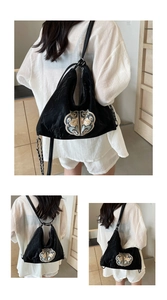Detail of embroidered floral patterns on black velvet Hobo bag with leather strap