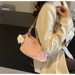 Pink minimalist crossbody bag styled on a beige blazer with a cute plush charm