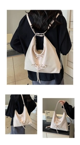 Detail of cream white versatile bag with bow tie decoration and silver chain strap