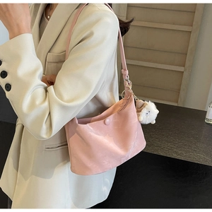 Pink dumpling style shoulder bag with fluffy sheep charm shown on a casual model