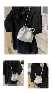 Détail du sac seau argenté avec nœud décoratif et finition métallique à texture fine