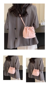Détail du sac seau en cuir mat rose clair avec nœud coulissant et bandoulière réglable