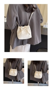 Détails du sac seau crème avec cordon de serrage, embouts en métal et texture cuir