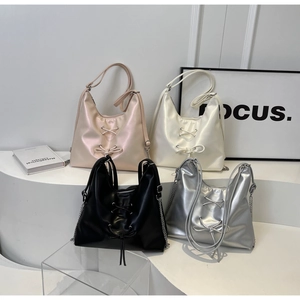 Detail showing high-shine tote bags in pink, cream, black and silver with bow accents
