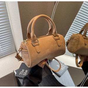 Detailed macro view of khaki Boston bag with suede texture and golden metal zippers