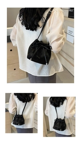 Détail du sac seau noir avec un grand nœud décoratif et une bandoulière réglable