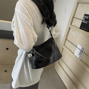 Fashionable black glossy pleated shoulder bag with silver sphere charm and leather strap