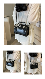 Détail du sac à bandoulière noir avec nœud en perles et étoiles argentées sur modèle