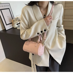 Detail of light pink mini Boston bag with gold metal hardware and fine leather texture