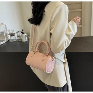 Close-up of light pink Boston bag with golden hardware and adjustable crossbody strap