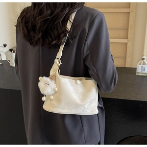 Detailed close-up of a white pleated PU leather shoulder bag with a plush doll charm accessory
