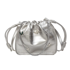 Silver metallic drawstring bucket bag with butterfly charms and chain strap on white background