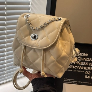 Quilted cream chain backpack with diamond stitching and metallic twist-lock closure
