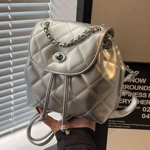 Silver quilted mini backpack with metallic chain straps and twist lock closure