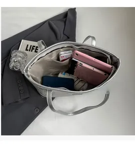 Detailed interior of a large silver tote bag showing spacious room for a tablet and phone