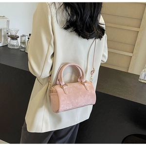 Detailed macro view of pink suede Boston bag with fine stitching and golden hardware