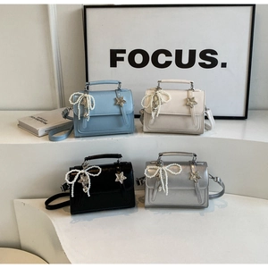 Détail de mini sacs bandoulière avec nœuds en perles et boucles étoiles en quatre tons