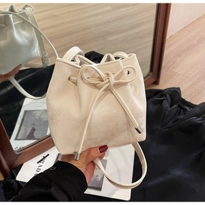 Détail du sac seau blanc crème avec cordon à nœud et embouts en métal argenté poli