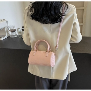 Detailed side view of a pink mini Boston bag with crossbody strap and side pocket