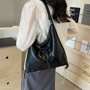 Minimalist large black crossbody bag featuring a ribbon bow and silver chain detail