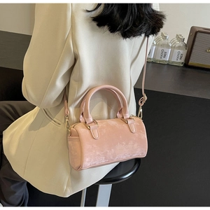 Detailed macro view of a pink velvet cylindrical Boston bag with fine suede texture