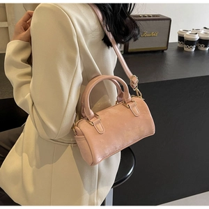 Detailed shot of pink Boston bag with gold metal hardware and detachable strap