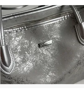 Close-up of metallic silver crackled tote bag with MEIGEFEI metal logo and top zipper