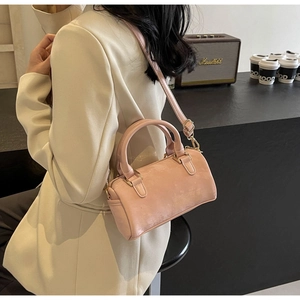 Detail view of pink Boston bag with textured finish and adjustable shoulder strap