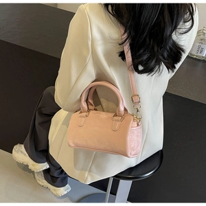 Pink Boston bag detail showing the adjustable strap and premium matte texture on model