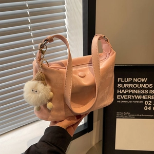 Minimalist light pink dumpling crossbody bag with a cute plush doll charm and strap