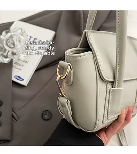 Detail of sage green handbag featuring golden D-ring hardware and fine stitching
