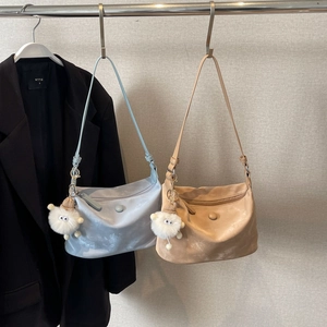 Minimalist crossbody dumpling bag in light blue and beige with plush sheep charm