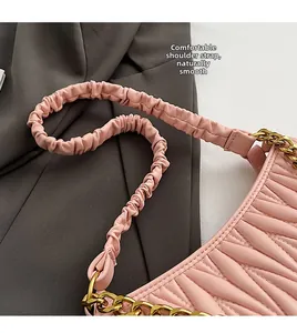Détail du sac en cuir plissé rose avec bandoulière souple et chaîne en métal doré