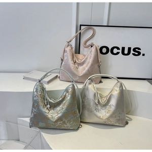 Detailed close-up of embroidered hobo bags in pink, green, and white colors