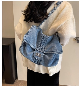 Sac fourre-tout en jean bleu avec chaîne argentée porté par un mannequin de profil