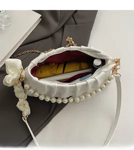 Interior view of white cloud bag showing space for phone, umbrella and cosmetics