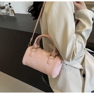 Detail of pink Boston handbag showing smooth matte leather texture and gold hardware
