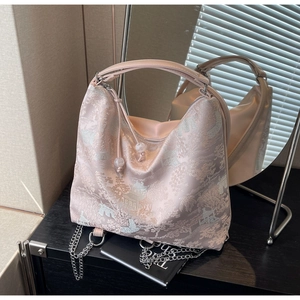 Detail of traditional Chinese embroidery on a pink satin hobo bag with a silver chain