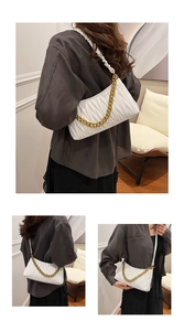 Détail du sac plissé matelassé blanc avec chaîne dorée et texture en cuir synthétique