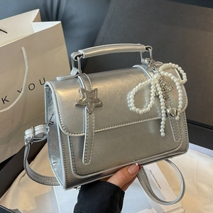 Sac bandoulière argenté brillant avec fermoir étoile et breloque nœud en perles