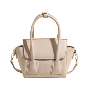 Elegant beige trapezoid bucket bag in matte leather with gold hardware and shoulder strap