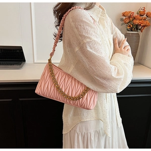 Vue détaillée du sac porté épaule matelassé rose avec une chaîne décorative dorée épaisse