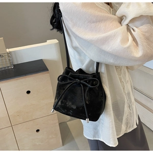 Détail du sac seau noir avec fermeture à cordon nœud papillon et embouts en métal argenté