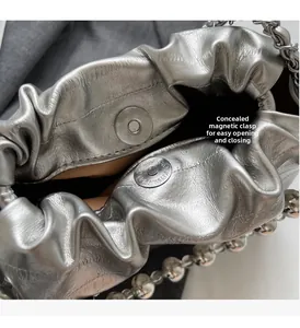 Macro detail of silver cloud bucket bag showing hidden magnetic closure and metallic lining