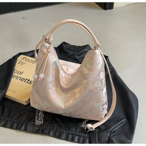 Detailed embroidery on pink hobo bag with pearl charms and delicate metal chain details